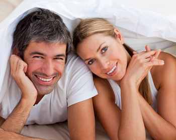 Enamoured couple having fun lying on a bed